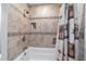 Close-up of tub and shower with decorative tile and recessed shower niche at 208 Se 32Nd Ave, Ocala, FL 34471