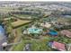 Birds-eye view of community pool area with winding walkways, lush vegetation, and a lake nearby at 1839 Via Lago Dr, Lakeland, FL 33810