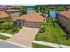 Aerial shot of a house with a three-car garage, tile roof, and well-kept lawn near a pond at 1839 Via Lago Dr, Lakeland, FL 33810