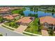 An aerial view showcases a beautiful home with a well-manicured lawn and a scenic lake in the background at 1839 Via Lago Dr, Lakeland, FL 33810