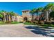 Elegant community clubhouse with a stone entrance, complemented by palm trees and beautiful landscaping at 1839 Via Lago Dr, Lakeland, FL 33810