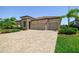 Charming single-story home with a brick driveway, tile roof, manicured landscaping, and a two-car garage at 1839 Via Lago Dr, Lakeland, FL 33810