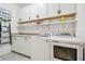 Laundry room featuring a washer, dryer, white cabinets, shelving, and a folding counter at 1839 Via Lago Dr, Lakeland, FL 33810