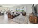 Open-concept living room featuring ceramic tile floors, a comfortable leather couch, and an outdoor view at 1839 Via Lago Dr, Lakeland, FL 33810