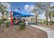 Community playground area with a large blue sun shade, slides, and climbing equipment at 1839 Via Lago Dr, Lakeland, FL 33810
