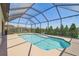 Relaxing pool area inside a screened enclosure, surrounded by black fence, and neighborhood view at 1839 Via Lago Dr, Lakeland, FL 33810