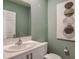 Well-lit half bathroom with a modern sink, toilet, and stylish wall art at 3762 King Hill Dr, Haines City, FL 33844