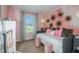 Charming bedroom featuring pink accents, decorative wallpaper, and a bright window view at 3762 King Hill Dr, Haines City, FL 33844