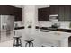 Modern kitchen features a large island with seating, stainless steel appliances, and dark wood cabinetry at 5431 Lewisham Dr, Davenport, FL 33837