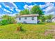Cozy backyard showcasing a well-maintained lawn and the home's exterior with a glimpse of the neighborhood at 211 W Crescent Dr, Lakeland, FL 33805