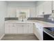Updated kitchen with white cabinetry, stainless appliances, and sleek countertops at 211 W Crescent Dr, Lakeland, FL 33805