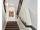 Carpeted stairs with a wooden railing lead to the upper level at 2437 Spring Tune Aly, Kissimmee, FL 34744