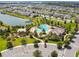 Aerial view of the community amenities featuring a pool, clubhouse, and a playground next to a lake at 4950 Chase Ct, St Cloud, FL 34772
