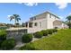 Backyard with lush landscaping, brick retaining wall, and partial view of the home's exterior at 4950 Chase Ct, St Cloud, FL 34772