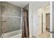 Bathroom with tiled shower and curtain, next to an open door featuring an additional walk-in closet at 4950 Chase Ct, St Cloud, FL 34772