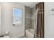 Modern bathroom featuring tiled shower with glass shelving, complemented by a bright window and fixtures at 4950 Chase Ct, St Cloud, FL 34772