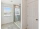 Bathroom featuring a glass-enclosed shower with neutral tile and a window for natural light at 4950 Chase Ct, St Cloud, FL 34772