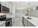 Modern kitchen with stainless appliances, quartz countertops, and an island with a sink at 4950 Chase Ct, St Cloud, FL 34772