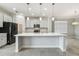 Open-concept kitchen with a large island, modern appliances, and bright lighting fixtures at 4950 Chase Ct, St Cloud, FL 34772