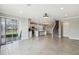 Open-concept living space with modern kitchen, staircase, and sliding doors to the pool area at 4950 Chase Ct, St Cloud, FL 34772