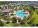 Aerial view of community pool featuring ample seating, clubhouse, and lush tropical landscaping at 4950 Chase Ct, St Cloud, FL 34772