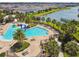 Aerial view of resort-style community pool featuring a splash pad, lounge chairs, and tropical landscaping at 4950 Chase Ct, St Cloud, FL 34772