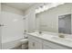 Bathroom with white cabinets, double sinks, large mirror, and combined shower and bathtub at 6690 Wake St, St Cloud, FL 34771