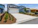 View of two-story home featuring a large driveway and a two-car garage at 6690 Wake St, St Cloud, FL 34771