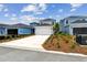 View of two-story home featuring a large driveway and a two-car garage at 6690 Wake St, St Cloud, FL 34771