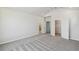 Bright main bedroom with vaulted ceilings, neutral walls, gray carpet, and doors to bathroom and walk-in closet at 6690 Wake St, St Cloud, FL 34771