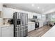 Bright kitchen features stainless steel appliances, white cabinetry, and modern wood-look flooring at 3839 White Ibis Rd, Lakeland, FL 33811