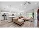 Open-concept living room with a large sectional couch, ceiling fan, and kitchen island at 3839 White Ibis Rd, Lakeland, FL 33811