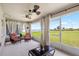 The screened-in patio features three ceiling fans and two chairs, with a large backyard view at 3839 White Ibis Rd, Lakeland, FL 33811