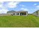 Spacious backyard featuring lush green grass, a covered patio, and ample room for outdoor activities at 5933 Slate Rock Dr, Lakeland, FL 33811