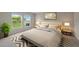 Cozy bedroom with neutral tones, tufted headboard, and bright windows overlooking the yard at 5933 Slate Rock Dr, Lakeland, FL 33811