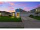 Inviting home at dusk features manicured lawn, attached garage, and warm interior lighting at 5933 Slate Rock Dr, Lakeland, FL 33811
