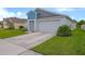 Modern two-story home with a two-car garage, lush landscaping and a well-maintained lawn at 5933 Slate Rock Dr, Lakeland, FL 33811
