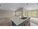 Modern kitchen with island, grey cabinetry, and open view to the living area at 5933 Slate Rock Dr, Lakeland, FL 33811