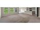 Open-concept living area with natural light, carpet flooring, and a modern kitchen at 5933 Slate Rock Dr, Lakeland, FL 33811
