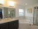 Luxurious bathroom with dual sinks, a soaking tub, and a separate glass-enclosed shower at 206 Samantha Ave, Auburndale, FL 33823