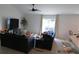 The living room has neutral colors with a ceiling fan and a view to the outside at 206 Samantha Ave, Auburndale, FL 33823