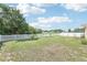 Expansive backyard with lush green grass, white picket fence, and mature trees at 4422 Evergreen Forest Loop, Kissimmee, FL 34758