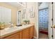 Bathroom with double sinks, wood cabinets, and an adjoining shower with patterned curtain at 4422 Evergreen Forest Loop, Kissimmee, FL 34758