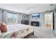 Primary bedroom with a floral-patterned bedspread, large windows, and a ceiling fan at 4422 Evergreen Forest Loop, Kissimmee, FL 34758