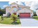 Charming two-story home featuring a well-manicured lawn, mature landscaping and a two car garage at 4422 Evergreen Forest Loop, Kissimmee, FL 34758