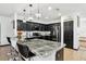 Modern kitchen featuring sleek black cabinetry, stainless steel appliances, and a spacious island at 4422 Evergreen Forest Loop, Kissimmee, FL 34758