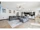 Open-concept living area with a gray sectional couch, modern rug, and an open view to the kitchen at 4422 Evergreen Forest Loop, Kissimmee, FL 34758