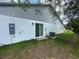 Back exterior view featuring a sliding glass door, an air conditioning unit, and partial siding at 1251 Dosseywood Ln, Lakeland, FL 33811