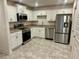 Modern kitchen featuring white cabinets, stainless steel appliances, and durable laminate countertops at 1253 Dosseywood Ln, Lakeland, FL 33811