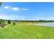 Scenic backyard view showcasing the manicured lawn and a peaceful pond surrounded by green landscape at 2612 Canyon Crest Dr, Lakeland, FL 33811